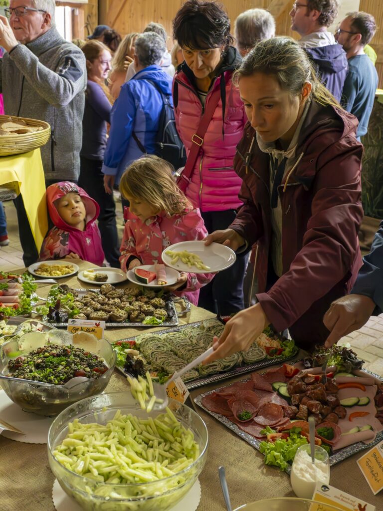 Frau mit Kindern bedient sich am Büfett beim Naturpark-Brunch auf dem Bauernhof