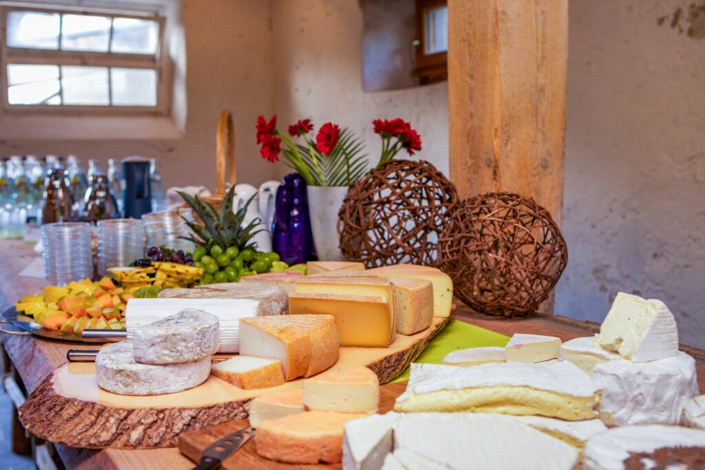 Unterschiedliche Käsesorten sind auf einem Holzbrett angerichtet.