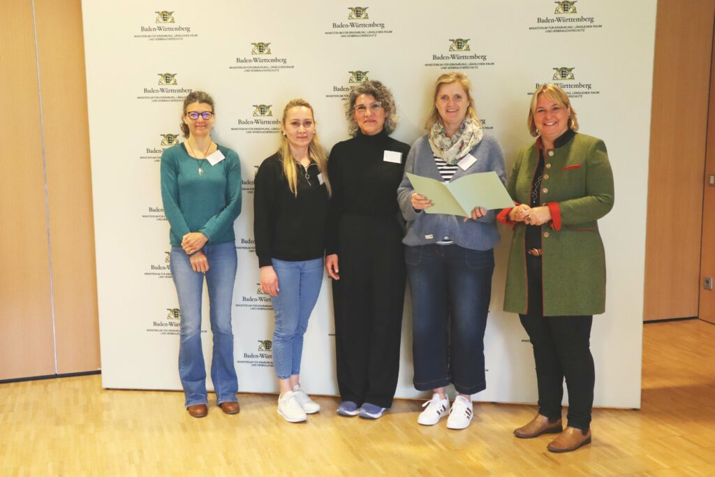 Fünf Frauen stehen nebeneinander. Eine Frau hält die Teilnahmeurkunde in ihren Händen.