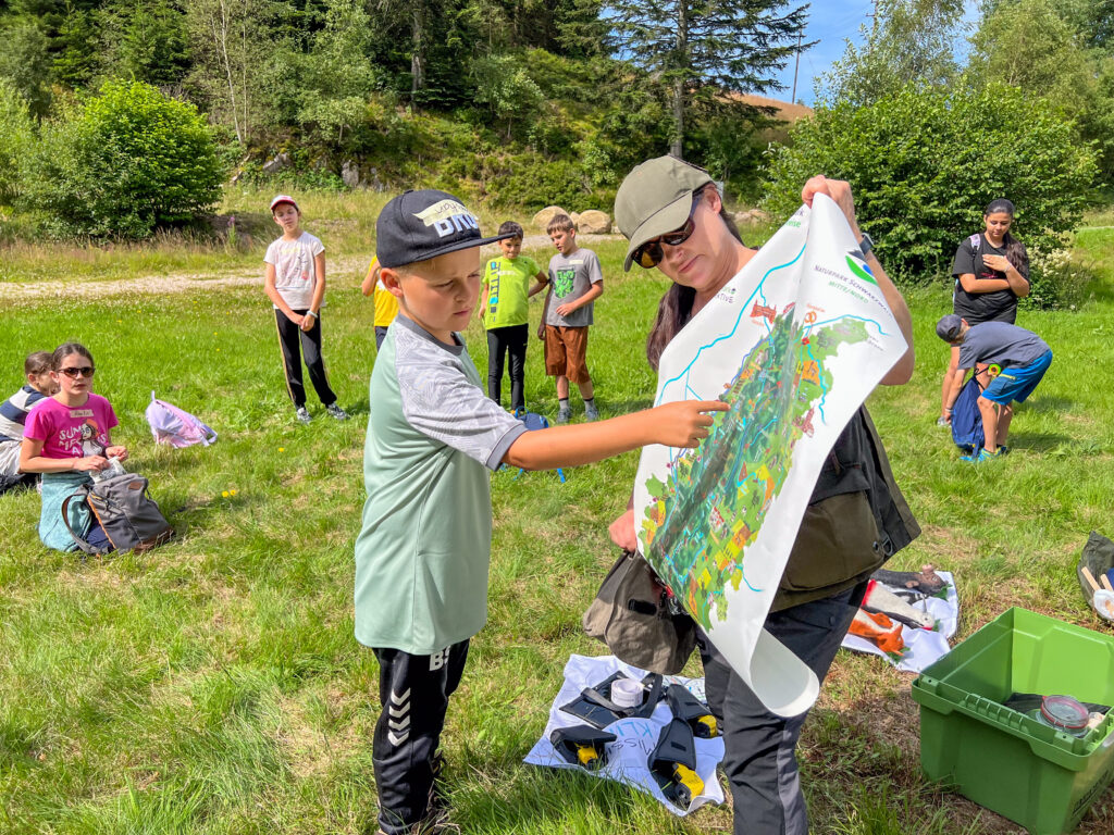 Ein Junge zeigt mit dem Finger auf die Naturpark-Karte