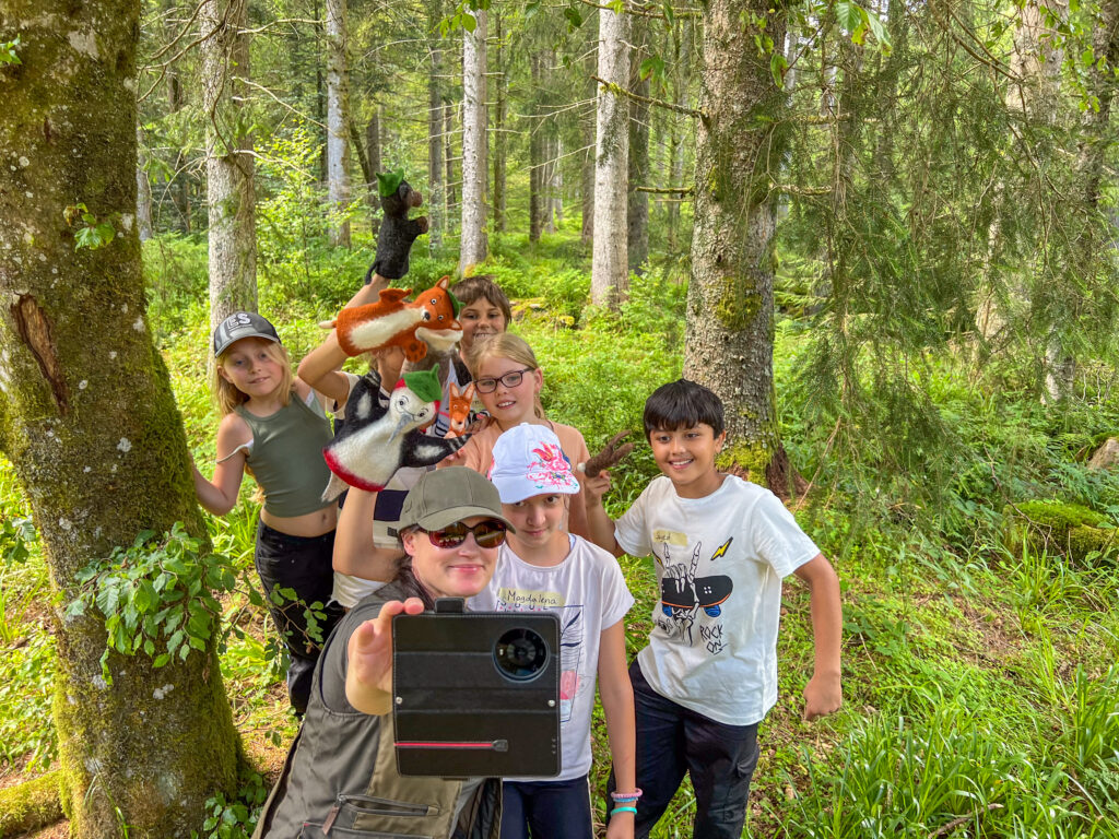 Frau macht Selfie mit Kindern und Handpuppen