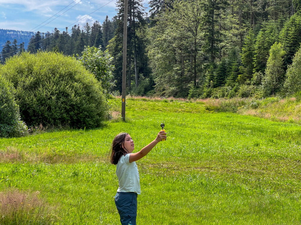 Mädchen hält Temperatur-Messgerät in die Luft