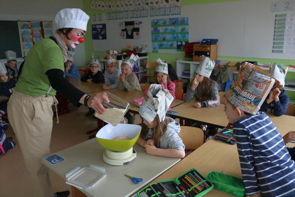 Eine Clownin backt mit Kindern Waffeln