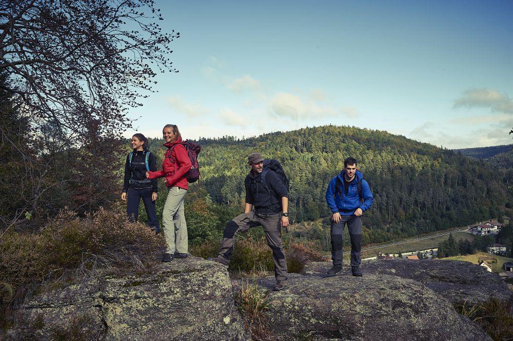 Menschen stehen auf einem Felsen mit Blick in den Schwarzwald.
