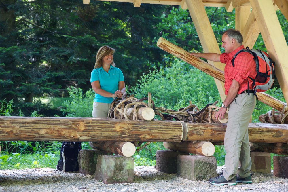 Ein Mann und eine Frau stehen an einem Flößer-Modell.