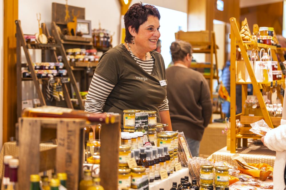 Frau steht an einem Verkaufsstand mit Honigprodukten