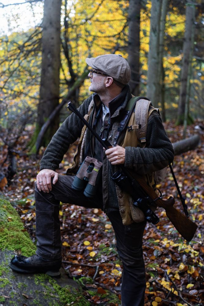 Jäger mit geschultertem Gewehr im Wald