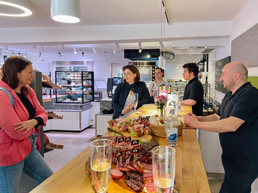 Menschen unterhalten sich in der Metzgerei