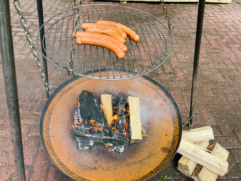 Feuerschale mit Würstchen auf dem Grillrost