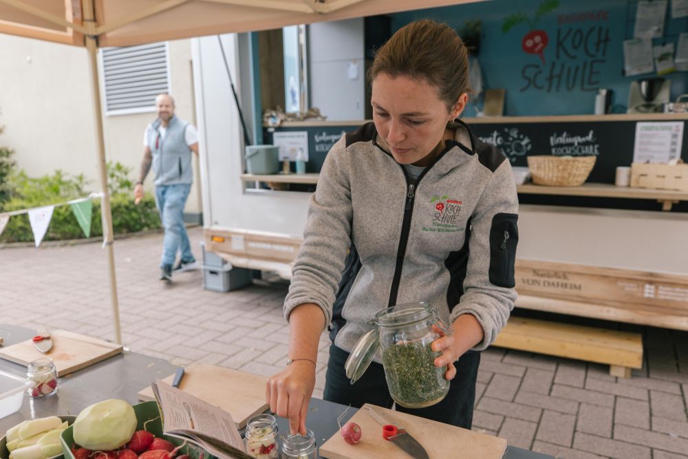 Eine Frau steht vor dem Naturpark-Kochschul-Bus