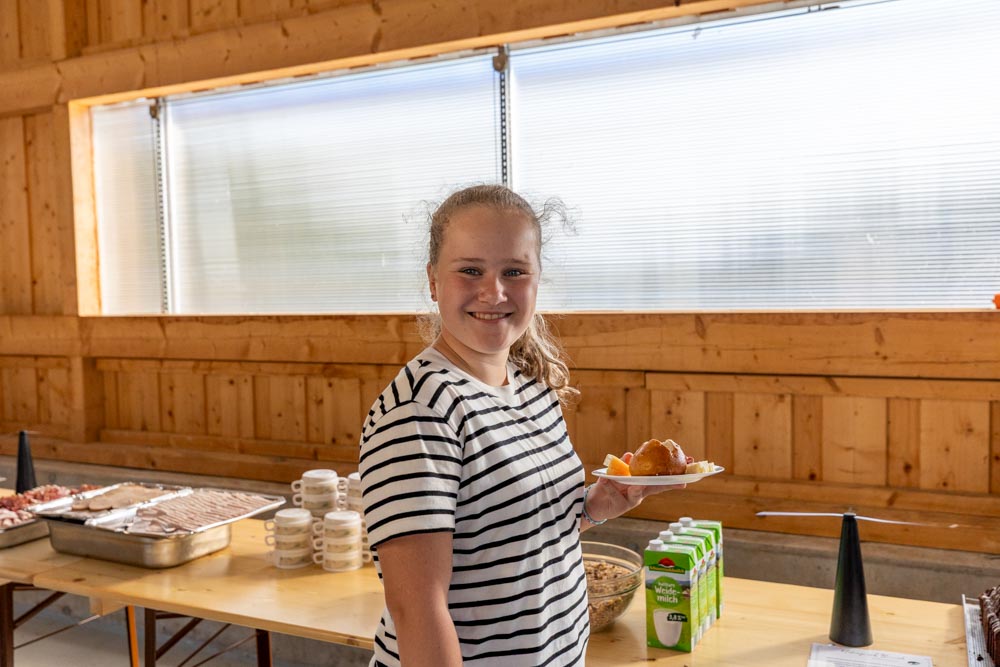 Ein Mädchen präsentiert seinen gefüllten Brunch-Teller.
