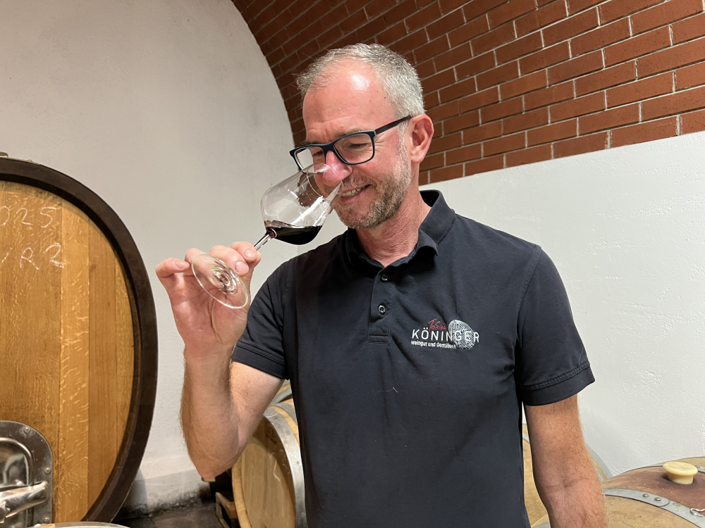 Tobias hält ein mit Rotwein gefülltes Glas an die Nase
