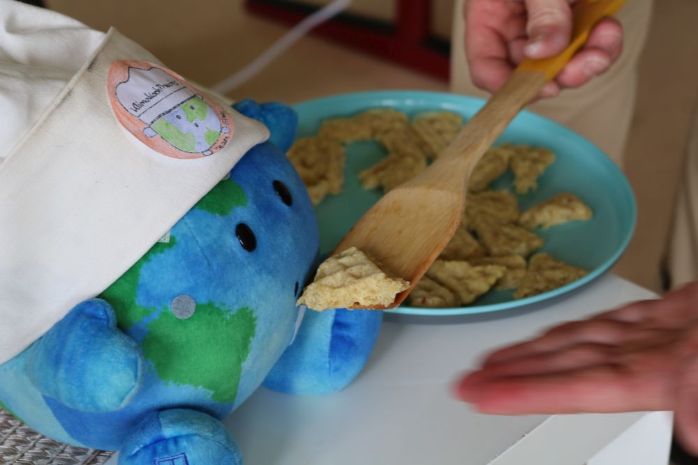 Plüscherde bekommt ein Waffelstück zu essen.