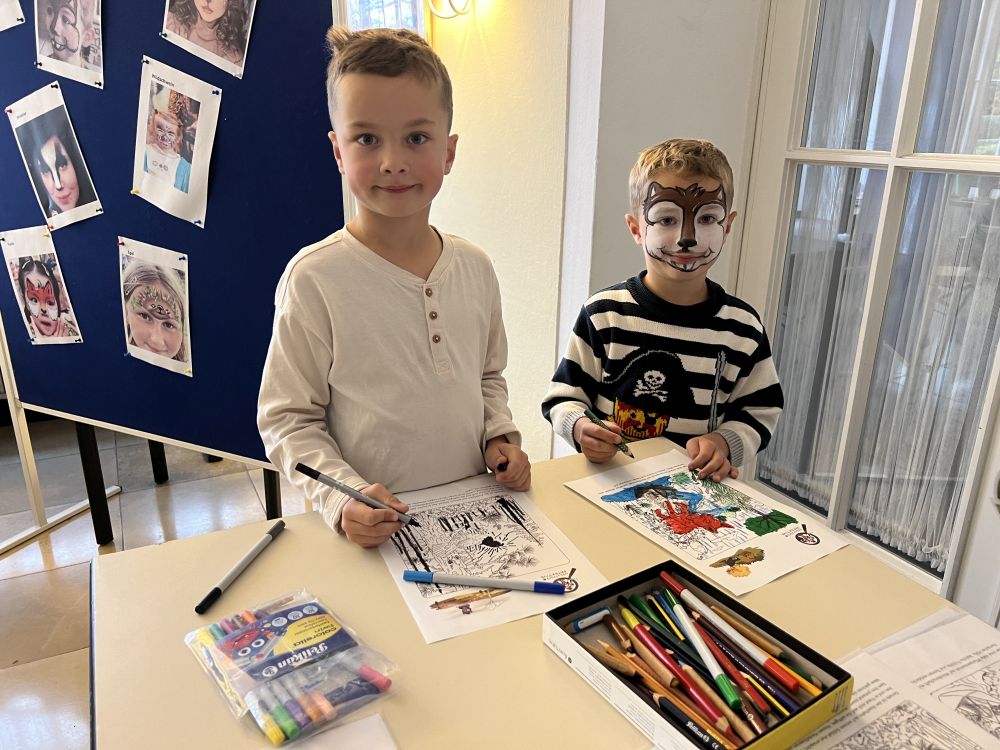 Kinder malen am Basteltisch.