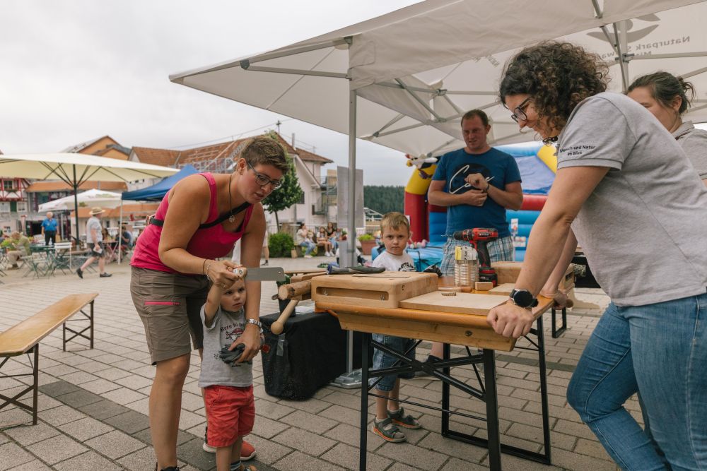 Kind sägt eine Holzscheibe