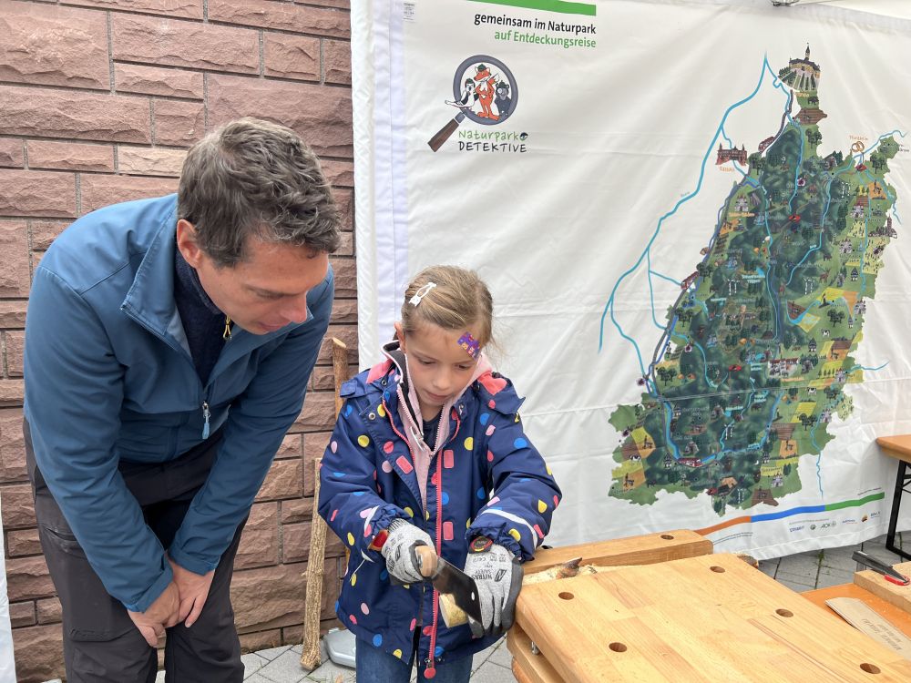 Mädchen sägt eine Holzscheibe