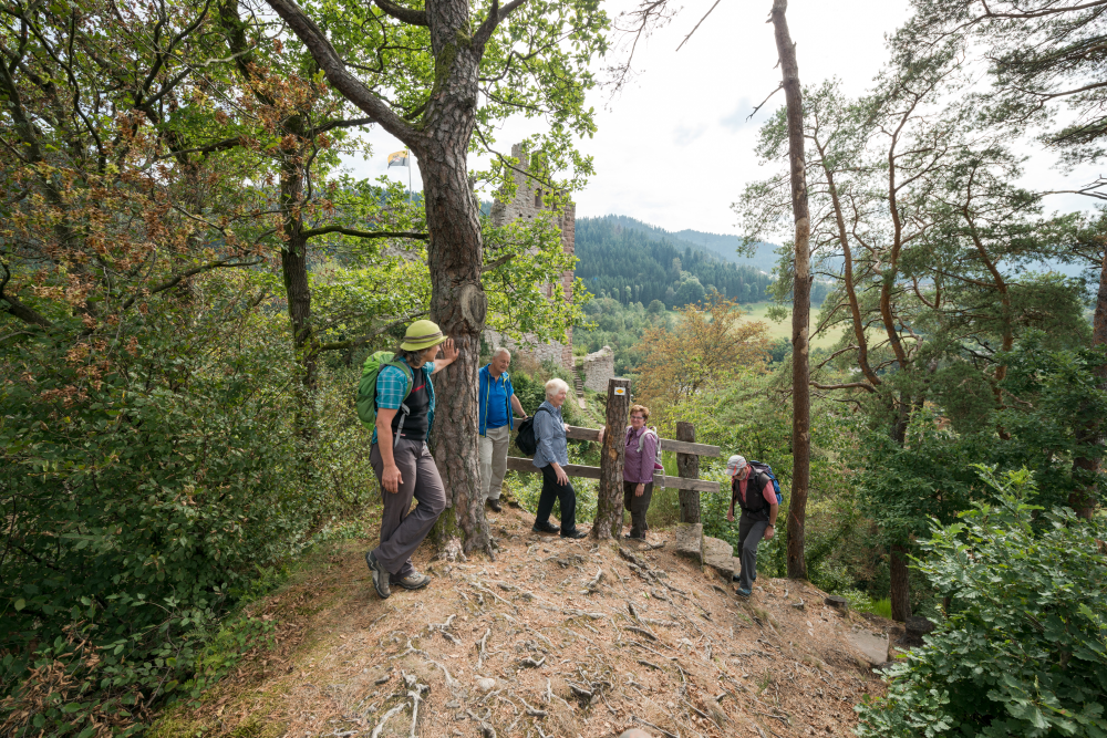 Augenblick Schiltach, Wandergruppe am Hang im Wald vor einer Ruine