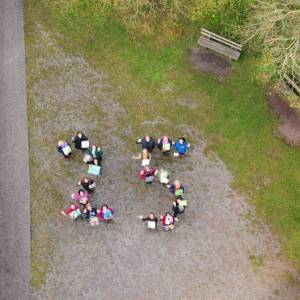 Menschen stellen sich zu einer aus der Vogelperspektive betrachteten 25 zusammen.
