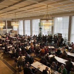 Menschen sitzen an Tischen im Festsaal Naturpark-Genuss-Messe in Freudenstadt
