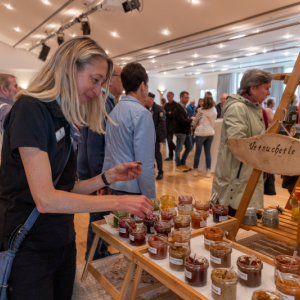 Eine Frau probiert Brotaufstriche an einem Stand.
