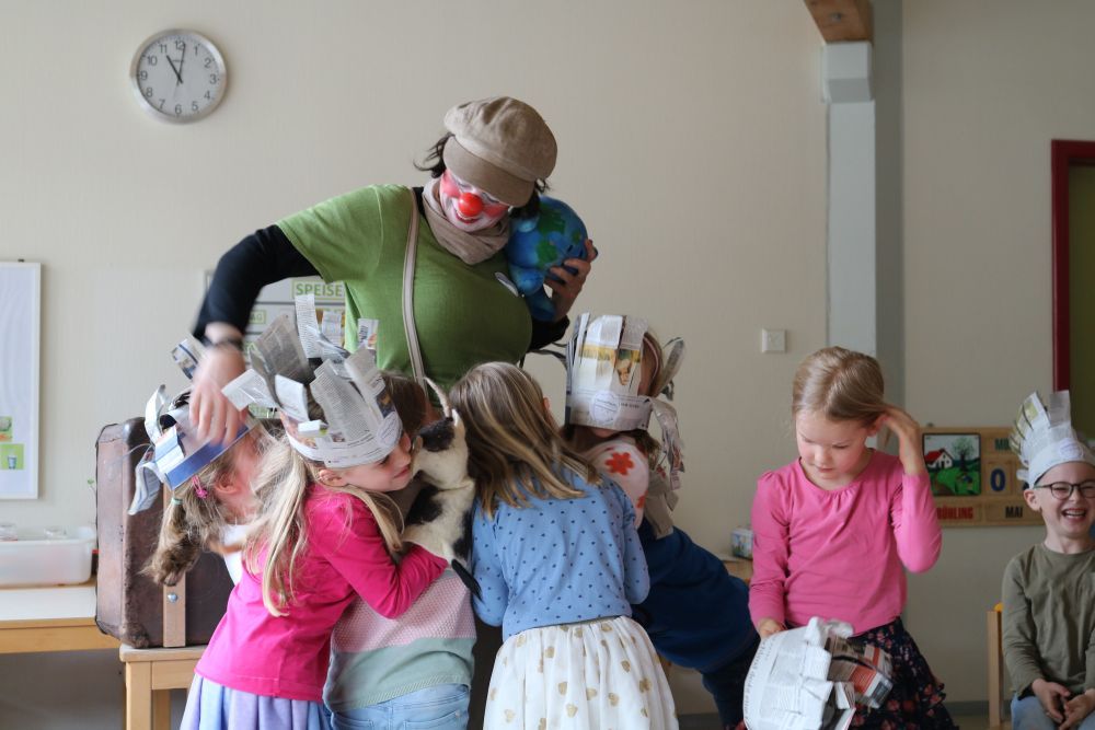 Kinder umarmen Clownin zum Abschied.