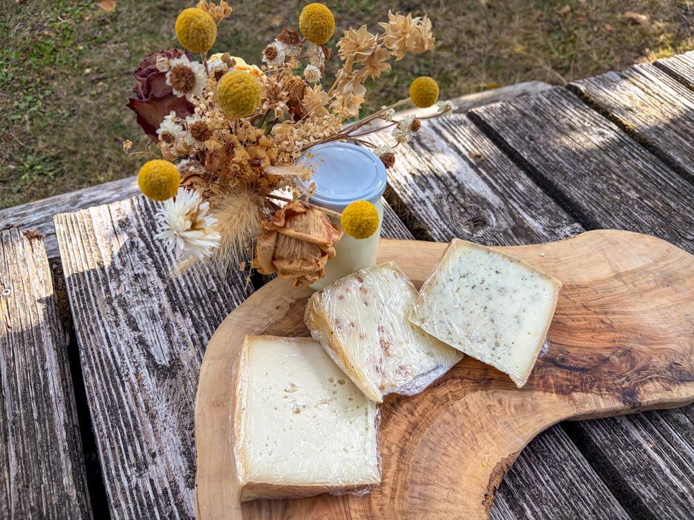 Schnittkäse auf einem Holzbrett mit Yogurt im Glas