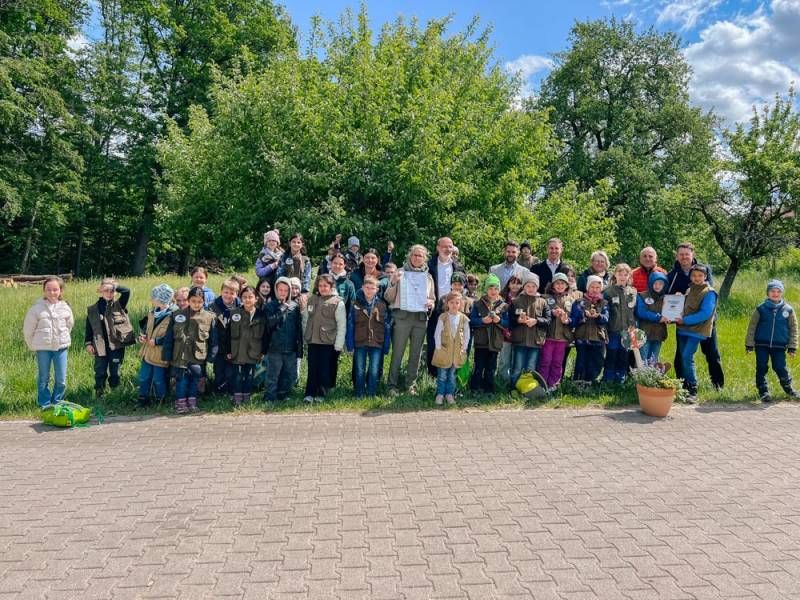 Gruppenbild: Kinder mit Erwachsenen vor einer Streuobstwiese