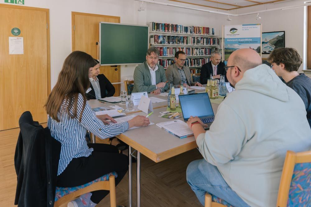 Menschen sitzen bei Pressegespräch zusammen