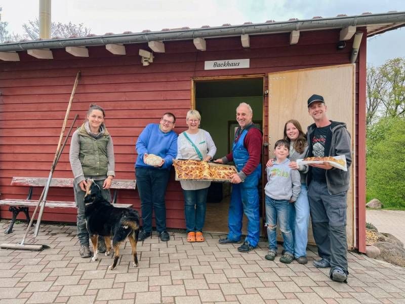 Familie Reiser vor dem Bauckhäusle mit Gästen und frisch gebackenen Hefezöpfen