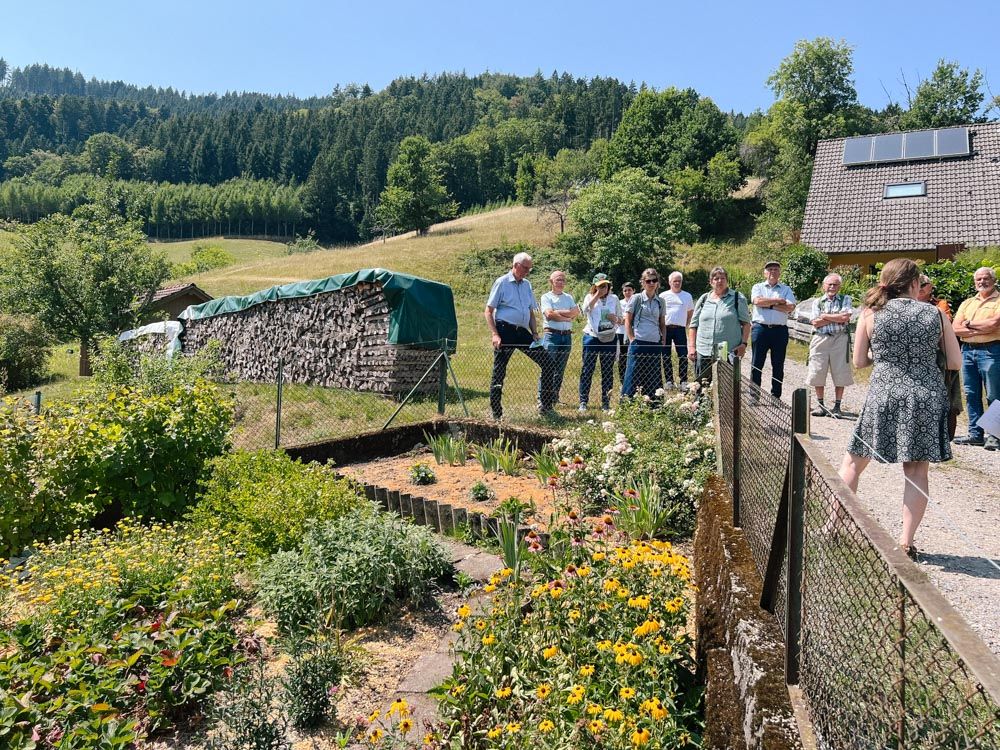 Menschen stehen vor Bauerngarten