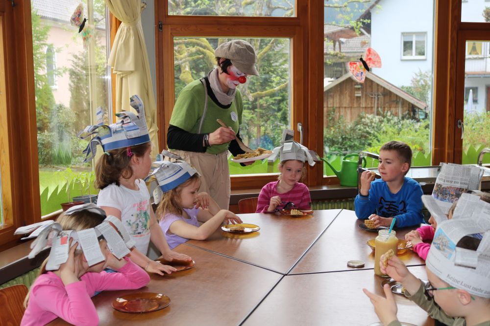 Clownin verteilt Waffeln an Kinder.