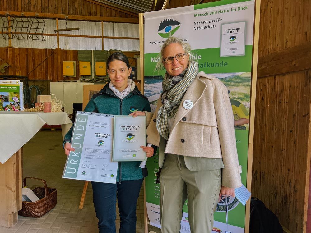 Die Stellv. Naturpark-Geschäftsführerin Yvonne Flesch überreicht der Schulleiterin Elisabeth Kiebelstein die Urkunde für die Auszeichnung zur Naturpark-Schule.