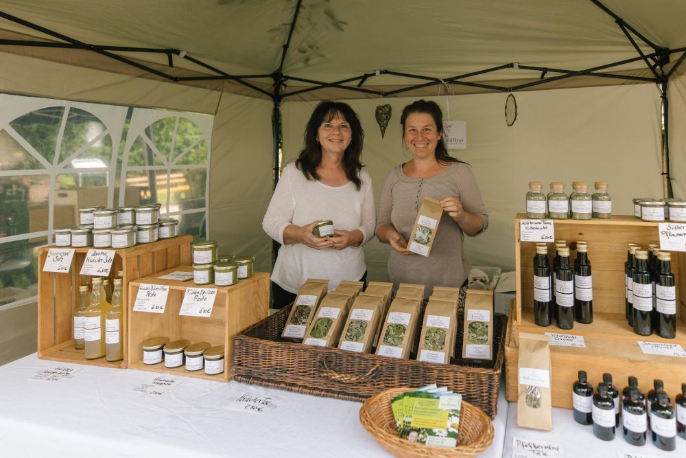 Zwei Frauen präsentieren an ihrem Stand ihre Kräuterprodukte.