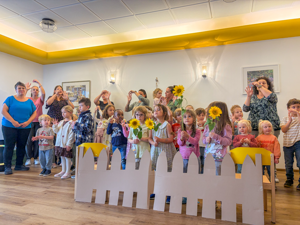 Kinder bei der Aufführung mit Sonnenblumen