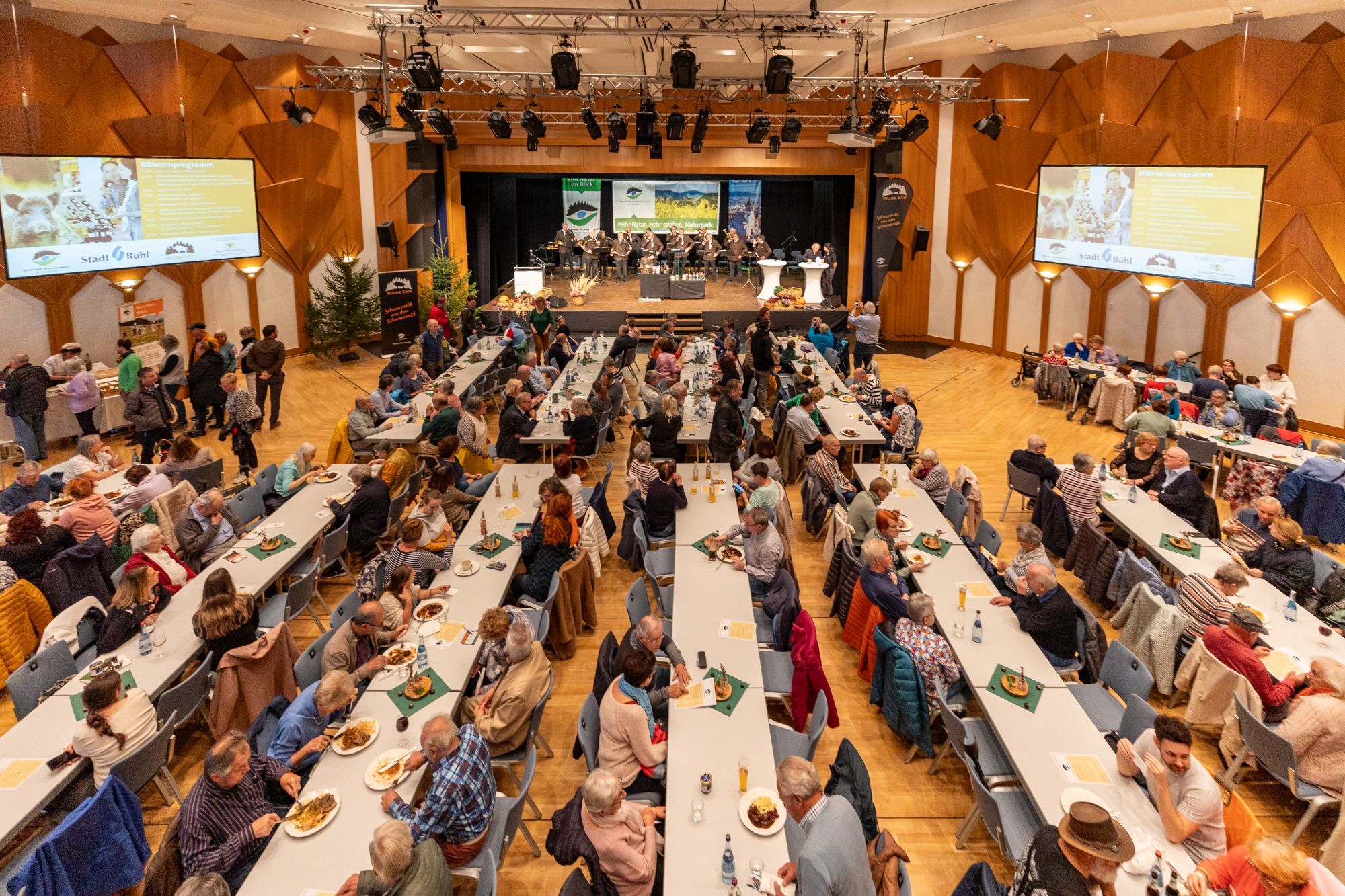 Menschen sitzen an langen Tischen bei der Naturpark-Genuss-Messe.