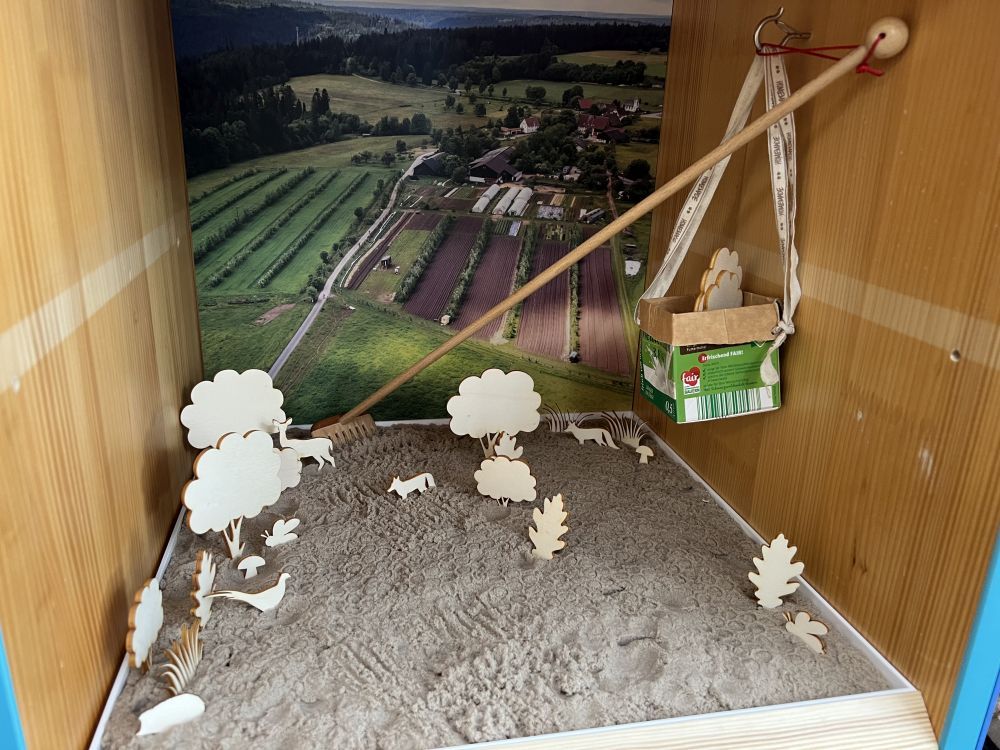 Knetsand mit Holzfiguren