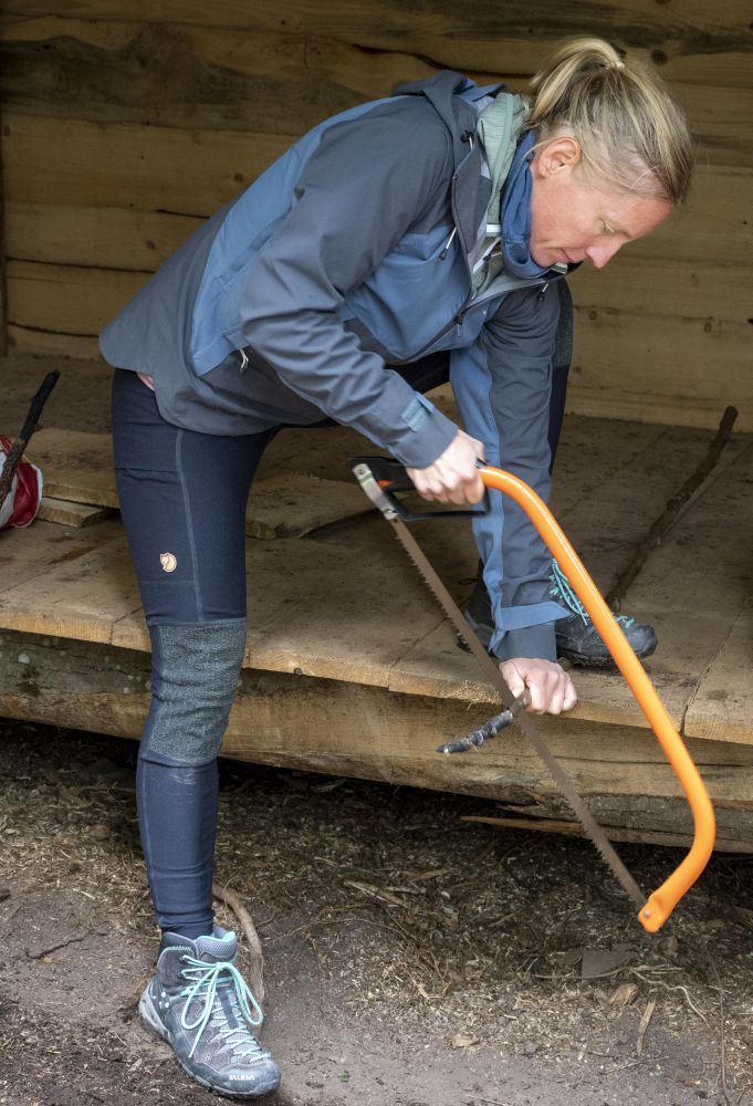 Eine Frau sägt einen Ast kleiner.