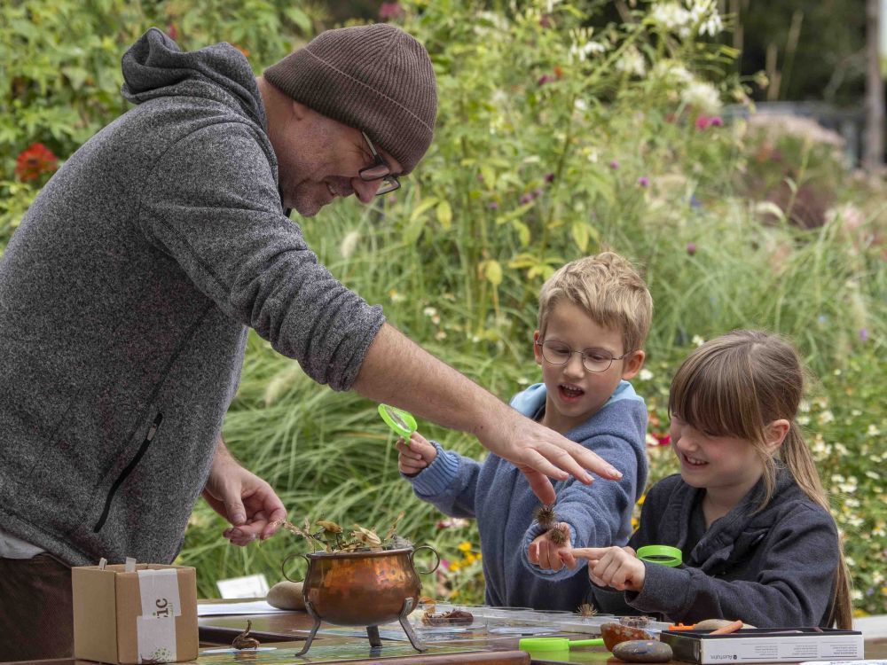 Zwei Kinder basteln mit Naturmaterialien.