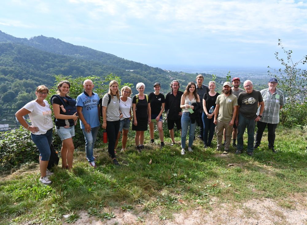 Menschen stehen vor der Vorbergzone in Bühlertal mit Blick in die Rheinebene.