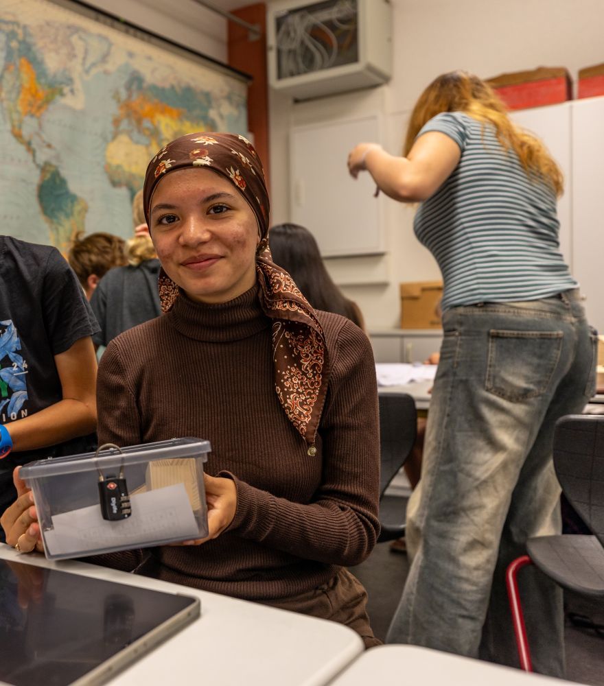 Ein Mädchen bastelt an einer Escape Box.