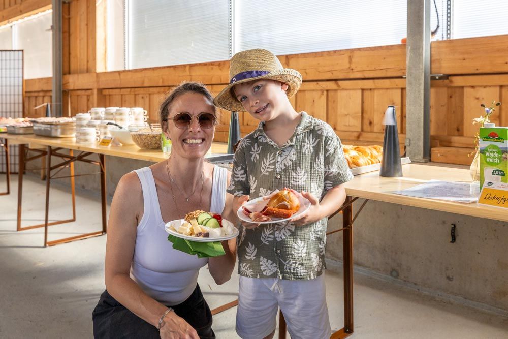 Frau mit Kind präsentieren ihre gefüllten Brunch-Teller.