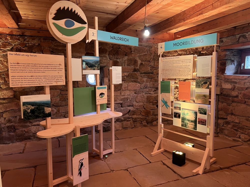Klima-Wanderausstellung Stellwand und Ausstellungstisch in einem alten Gebäude aus Stein