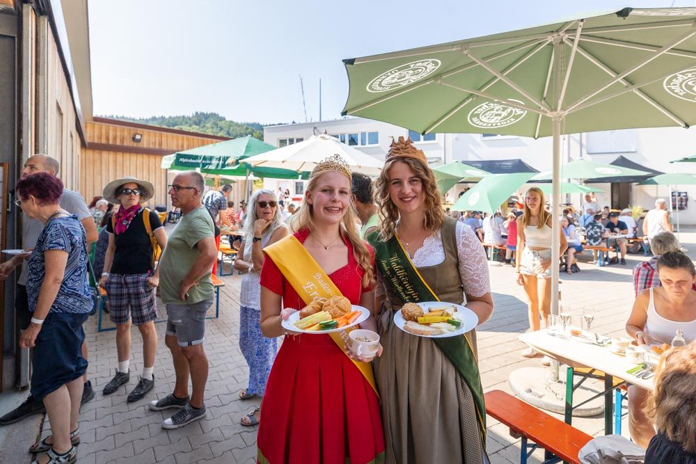Wein- und Erdbeerkönigin mit gefüllten Tellern beim Brunch auf dem Bauernhof
