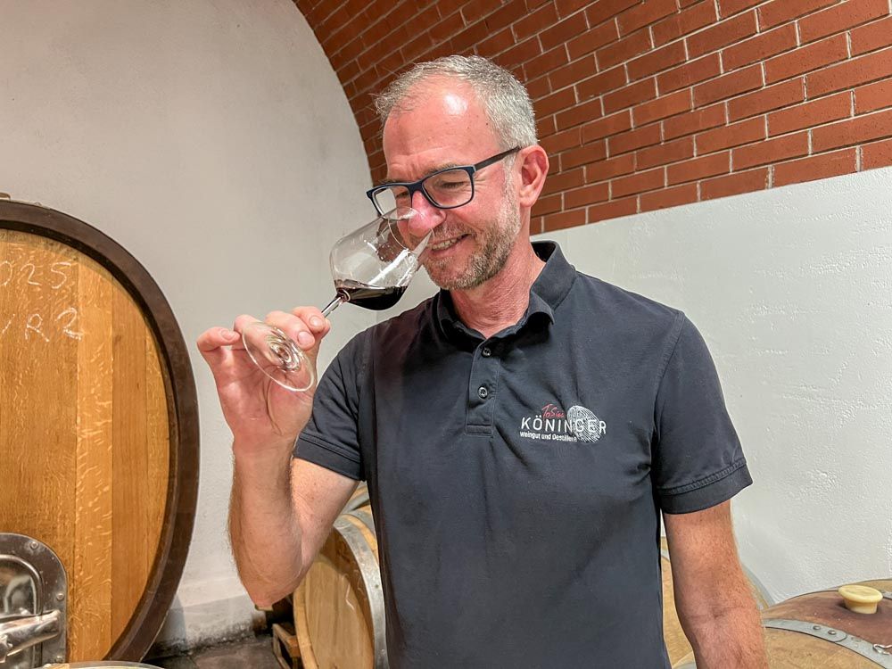 Tobias hält ein mit Rotwein gefülltes Glas an die Nase