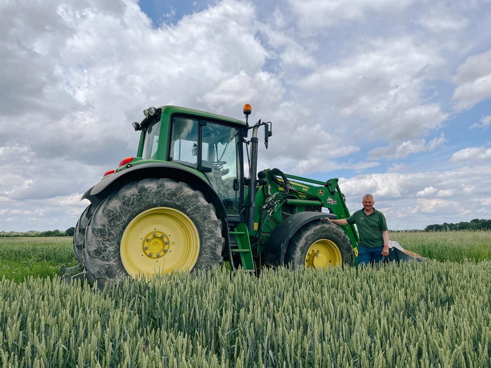 Landwirt Friedrich Wenz steht vor seinem Traktor auf dem Acker