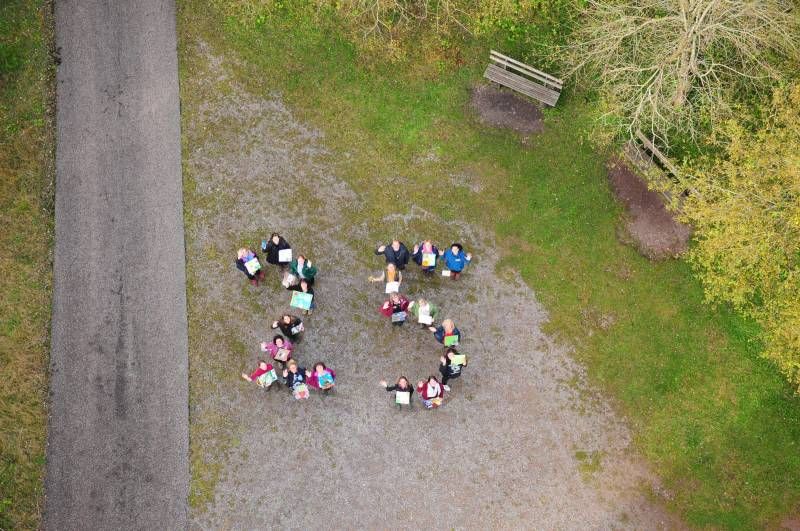 Menschen stellen sich zu einer aus der Vogelperspektive betrachteten 25 zusammen.