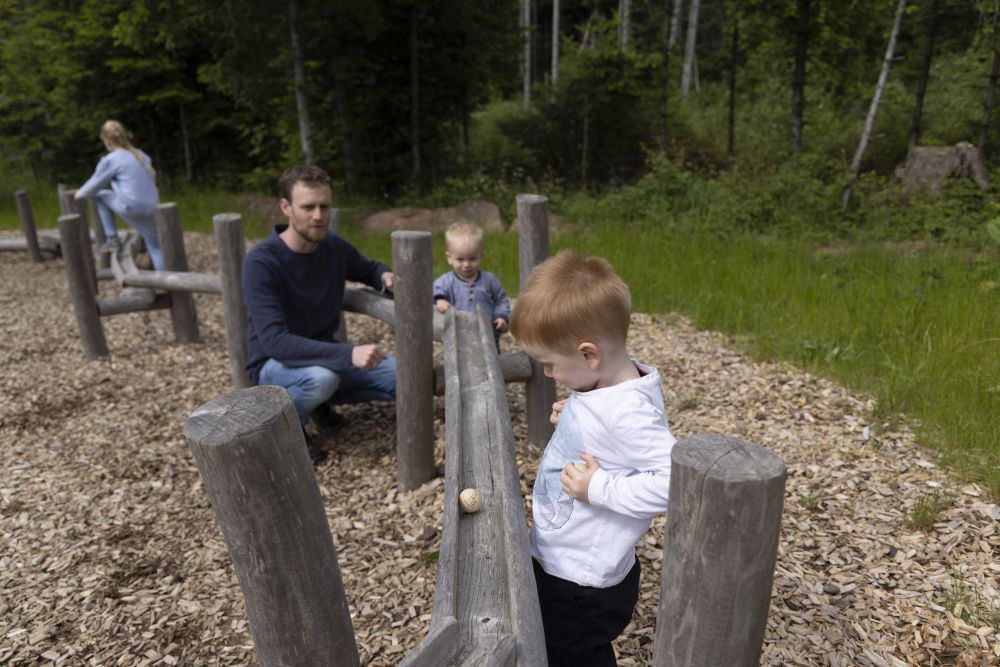 Kinder spielen bei einer Holzkugelbahn im Wald