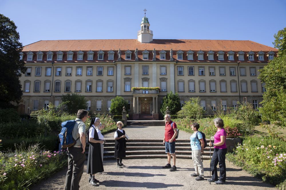 Menschen vor einem Klostergebäude