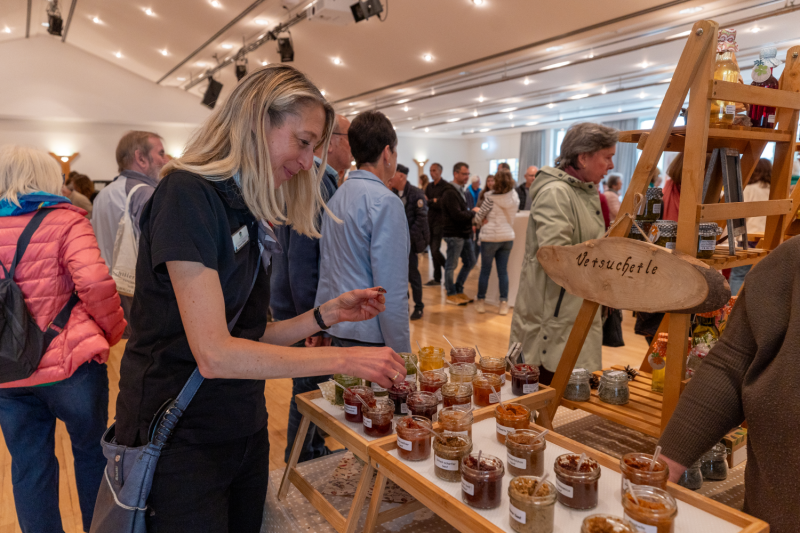 Eine Frau probiert Brotaufstriche an einem Stand.