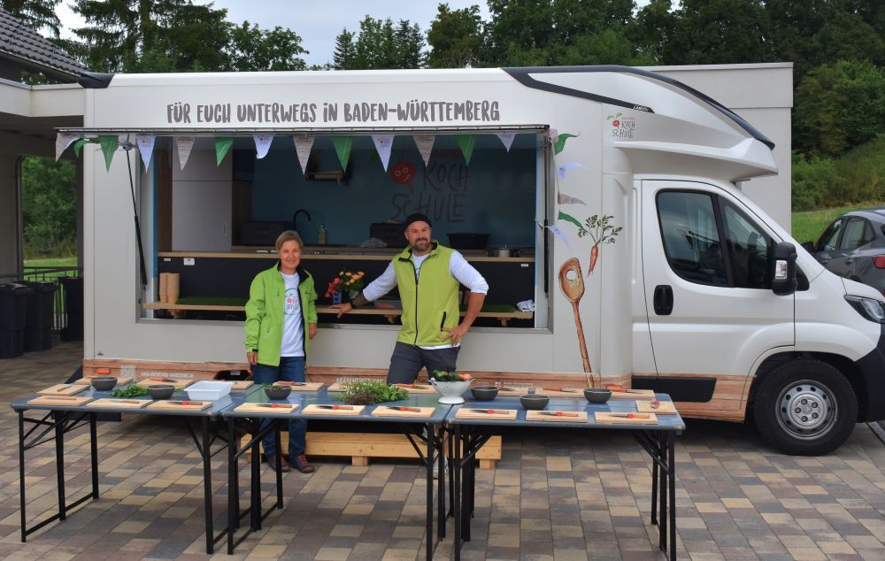 Zwei Menschen stehen vor einem Küchentruck